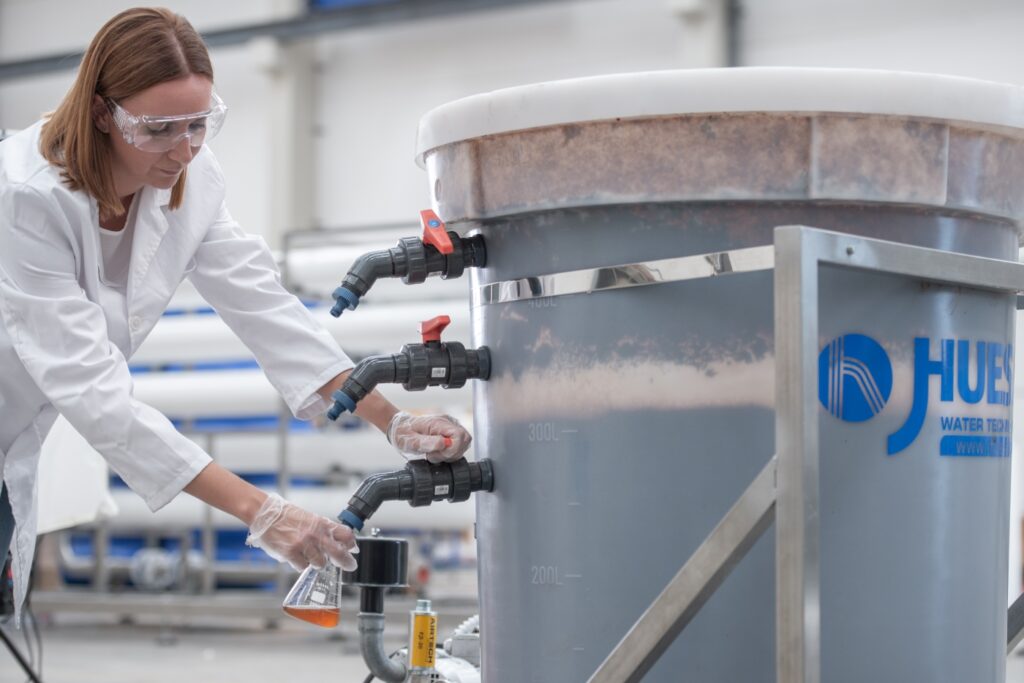 Técnico de Laboratorio que está tomando una muestra de agua